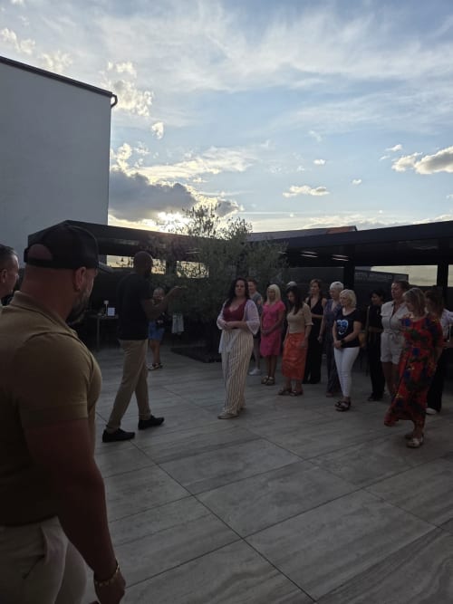 Group of guests gathered on terrace at Hôtel-Restaurant le S'Y in Seingbouse during evening event with cloudy sky