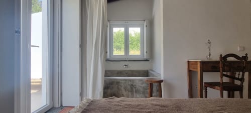 Quarto Pateo Superior em Monte Falperras com vista para o jardim, banheira junto à janela, móveis de madeira e acesso exterior