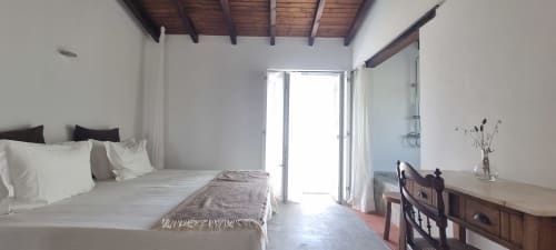 Quarto luminoso na Quinta Monte Falperras em Mourão com vista para jardim, vigas de madeira aparentes e portas para terraço
