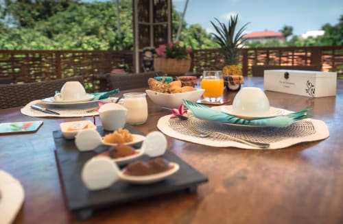 Petit-déjeuner tropical à l'hôtel La Maison de Clementine à Fort-de-France avec viennoiseries fraîches, jus et vue sur l'océan