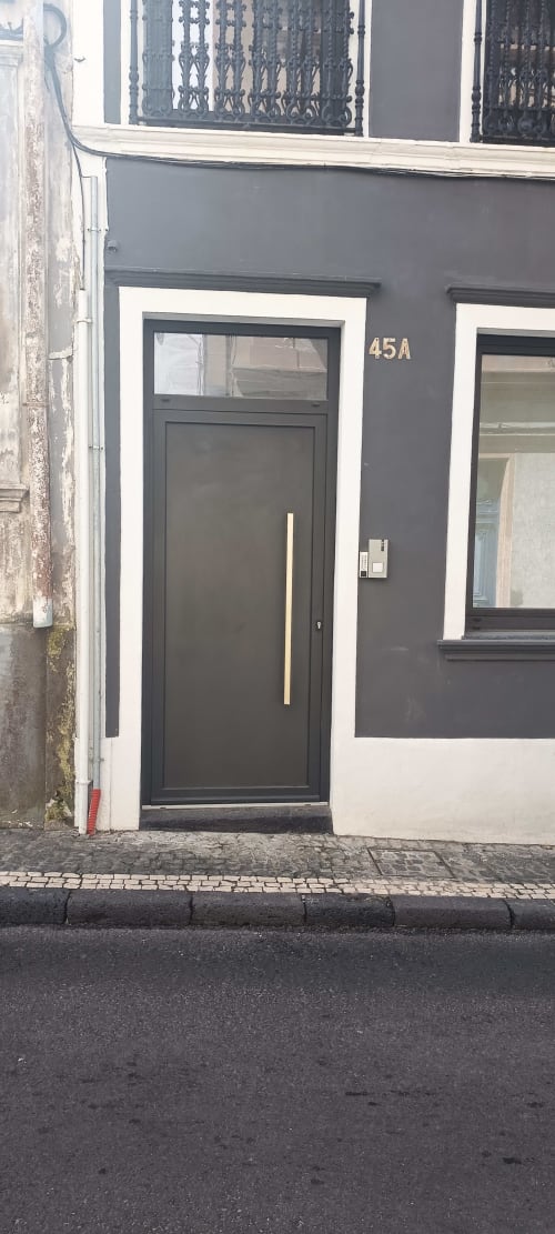 Modern black door entrance at Pés Verdes Hostel apartment (45A) in Ponta Delgada, Portugal