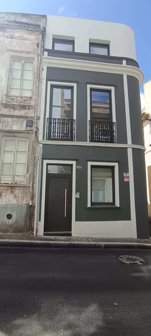 Modern dark and white apartment building at Pés Verdes Hostel in Ponta Delgada, Portugal with curved facade and black