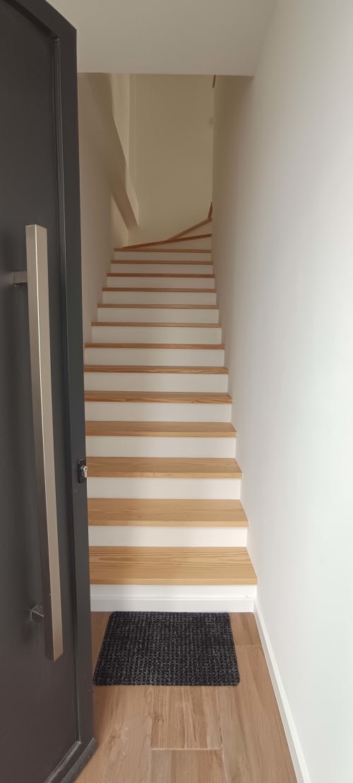 Wooden staircase with white risers leading upstairs in Pés Verdes Hostel apartment, Ponta Delgada