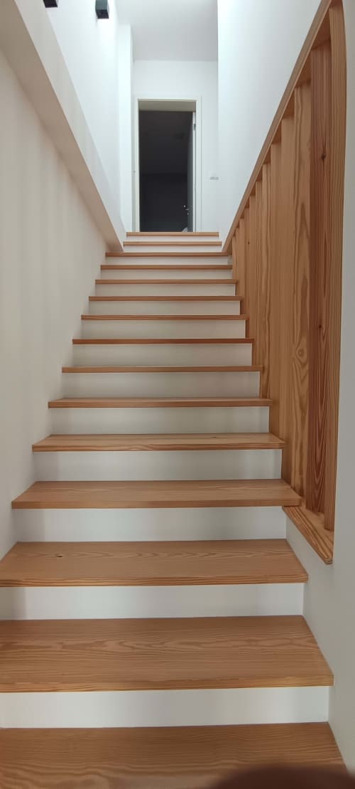 Wooden staircase with white walls leading to upper floors at Pés Verdes Hostel in Ponta Delgada
