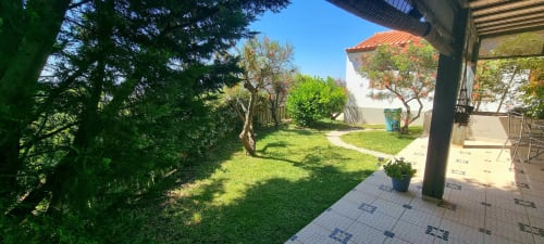Pátio exuberante com gramado cuidado, árvores maduras e terraço de pedra no hotel rural SELÃO DA EIRA no Alentejo