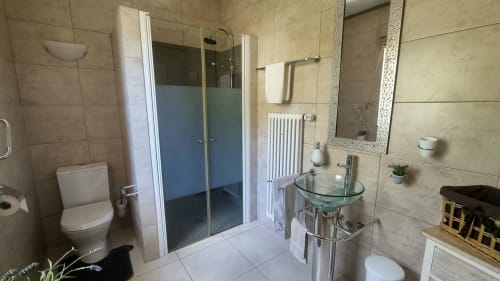 Banheiro moderno com chuveiro, vaso sanitário e pia de vidro no quarto CASA PEIXE de SELÃO DA EIRA, Portugal