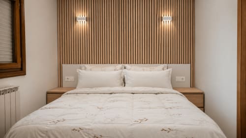Dormitorio moderno en Matzuri Nekazalturismoa de Mutriku con cabecero de madera, ropa de cama blanca e iluminación ambiental