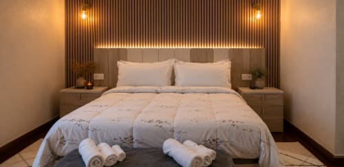 Dormitorio moderno en MATZURI Agroturismo de Mutriku con detalles de madera, iluminación ambiental y vistas a la montaña
