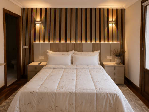 Dormitorio moderno en MATZURI NEKAZALTURISMOA en Mutriku con cama de madera, ropa de cama neutra, apliques de pared y vistas a las montañas desde