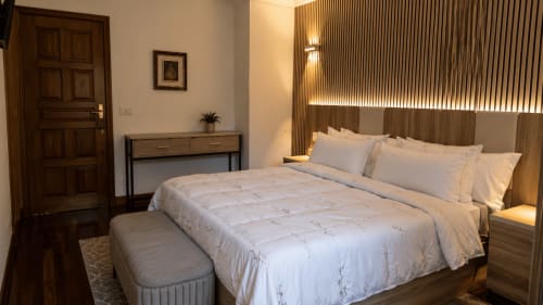 Moderno dormitorio en MATZURI NEKAZALTURISMOA con vistas al mar, cama de matrimonio, muebles de madera e iluminación ambiental en Mutriku