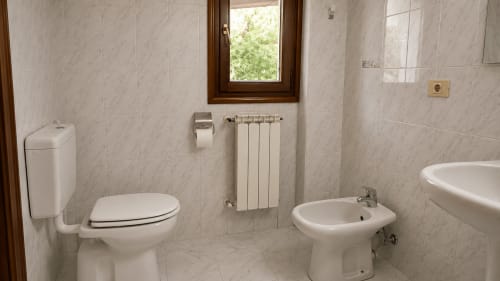 Baño en MATZURI NEKAZALTURISMOA con inodoro, bidé, radiador y ventana en el hotel de Mutriku