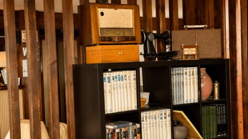 Radio antigua, máquina de coser y estanterías con DVDs y coleccionables en el hotel rural Matzuri Nekazalturismoa, Mutriku