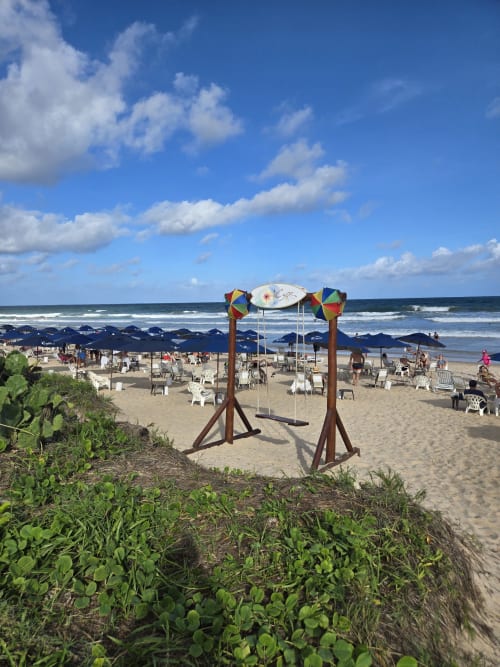 Coloridos balanços de praia no Labedi Apartamentos em Porto de Galinhas com guarda-sóis e vista para o oceano