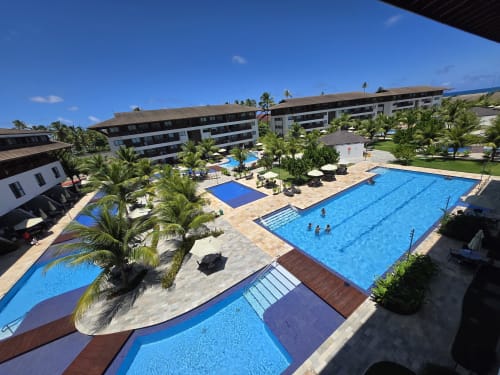 Complexo de piscinas boutique Labedi Apartamentos em Porto de Galinhas com múltiplas piscinas, palmeiras e design moderno branco