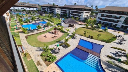Vista aérea do Labedi Apartamentos com piscinas, praia arenosa e jardins tropicais em Porto de Galinhas