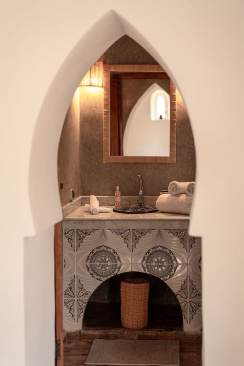 Arched bathroom vanity at Domaine Belhazar, Essaouira with decorative basin and mirror