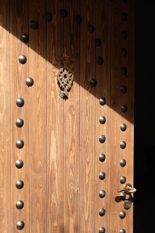 Wooden door with decorative metal studs at Domaine Belhazar in Essaouira, Morocco