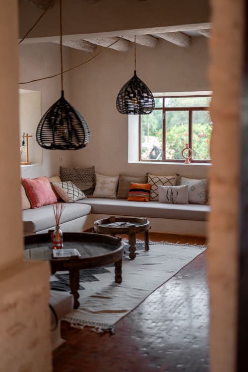 Elegant sitting room at Domaine Belhazar in Essaouira with woven pendant lights, window seat, and traditional decor