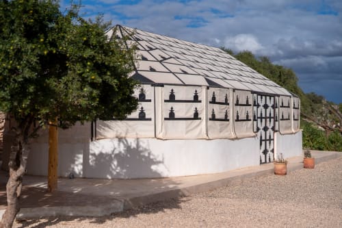 Modern white greenhouse structure at Domaine Belhazar in Essaouira with geometric roof design and Mediterranean landscaping
