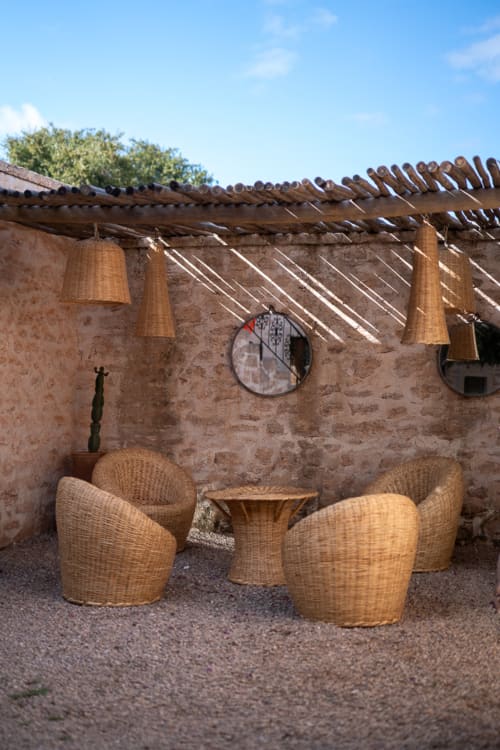 Woven lounge chairs on a terrace at Domaine Belhazar, Essaouira with rustic stone walls and pergola
