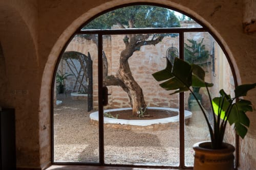Arched doorway opening to courtyard with ancient olive tree, Domaine Belhazar, Essaouira