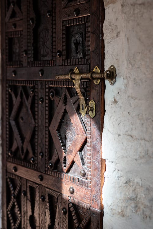 Ornate wooden door with brass latch at Domaine Belhazar, Essaouira Morocco boutique accommodation