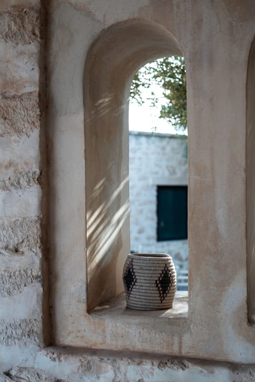 Stone arches and woven basket at Domaine Belhazar in Essaouira, Morocco
