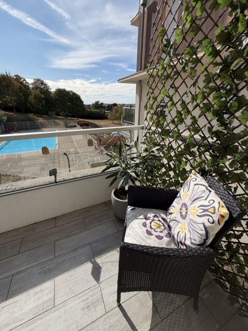 Balcon avec vue sur la piscine à Appart'NoOm, treillis de lierre et paysage montagneux