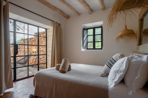Chambre sereine au gîte Domaine Belhazar à Essaouira avec poutres apparentes, vue sur la terracotta et équipements modernes