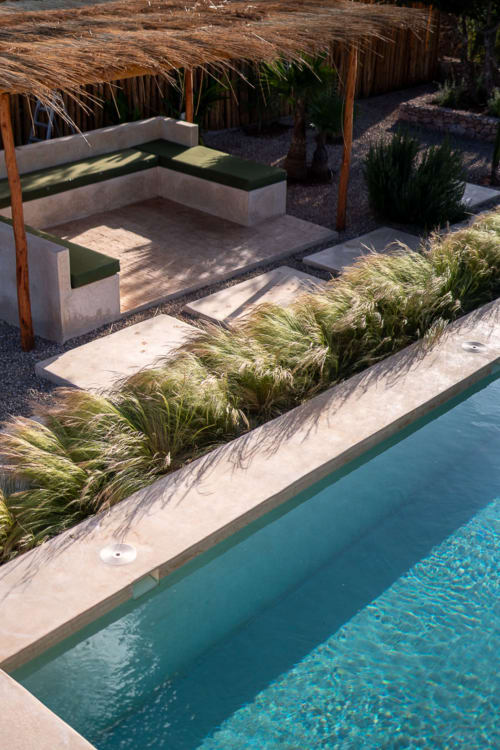 Piscine turquoise avec transats, toits de chaume et herbes ornementales au Domaine Belhazar à Essaouira