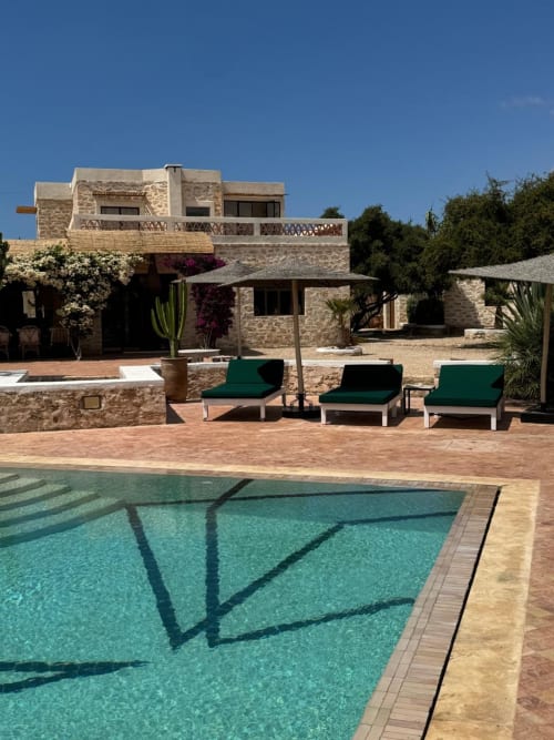 Domaine Belhazar pool view in Essaouira with stone villa, lounge chairs, and turquoise swimming pool