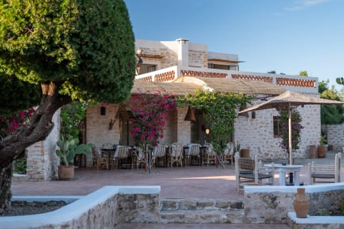 Terrasse du Domaine Belhazar à Essaouira avec architecture en pierre, bougainvillée magenta et sièges de restauration