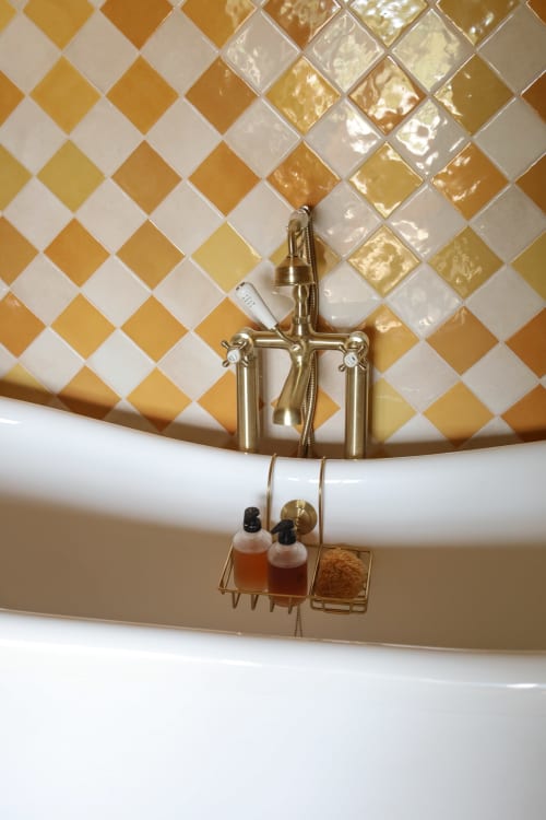 Salle de bains à La Roquerie avec carrelage or et blanc, robinetterie en laiton et porte-accessoires