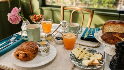 Petit-déjeuner élégant à La Maison 1903 B&B à Trévou-Tréguignec : viennoiseries, fromages, jus frais et fleurs roses