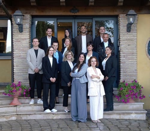 Team professionale dell'Hotel Green Poggio Regillo di Frascati, Italia in posa sui gradini dell'ingresso