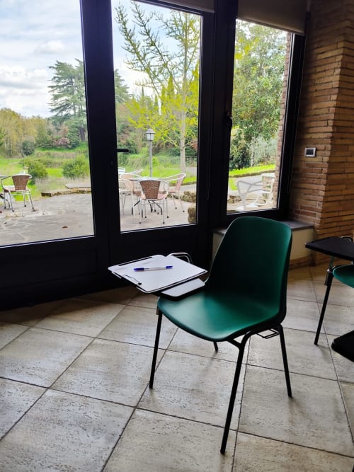 Moderna poltrona verde presso la Green Hotel Poggio Regillo di Frascati, con vista sui giardini attraverso ampie finestre