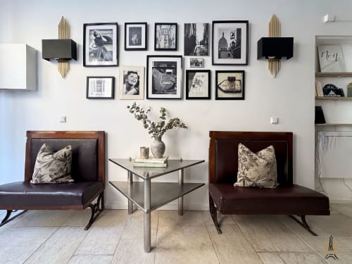 Montmartre Apartments Paris: Modern sitting area with two brown leather chairs, metal table, black and white framed photos,
