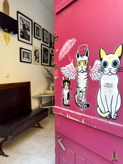 Whimsical angel cat street art on pink wall in Montmartre Apartments Paris apartment, Androuet Atelier room with vintage