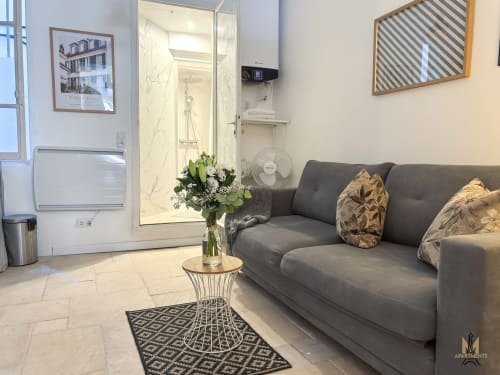 Modern living room at Montmartre Apartments Paris with gray sofa, marble bathroom, and contemporary decor