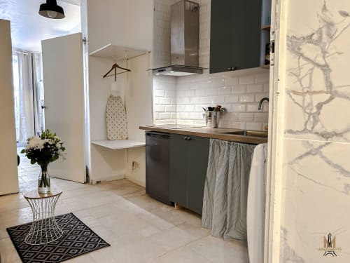 Modern kitchenette in Androuet Atelier apartment at Montmartre Apartments, Paris, with white subway tile backsplash and dark