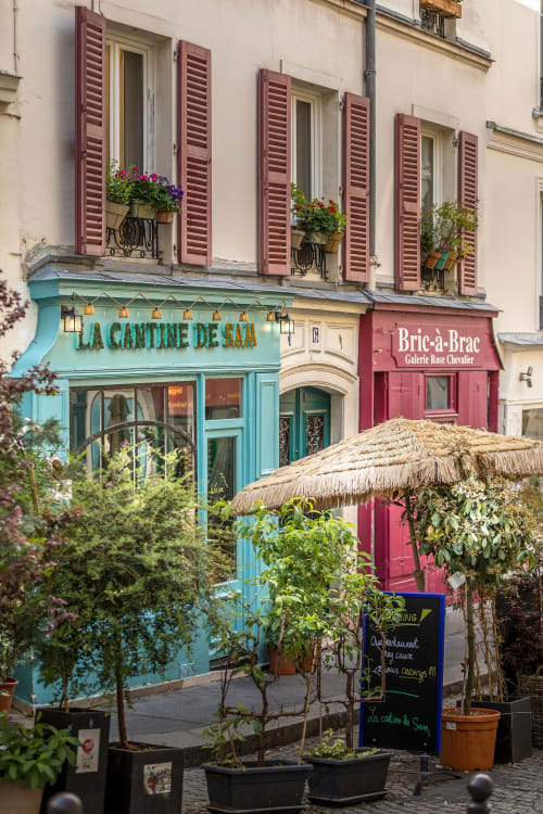 Charming Montmartre storefront with turquoise La Cantine de Sar cafe and burgundy Bric-à-Brac gallery below Parisian