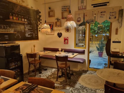 Cozy breakfast room at Gites Mas D'en Ratéro in Thuir with booth seating, pendant lights, and patio view
