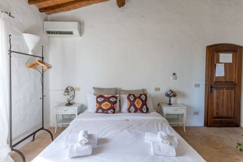 Camera Olmo dell'hotel Quarantallina a Buonconvento con pareti bianche, travi in legno, aria condizionata e letti gemelli