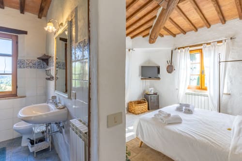Camera Olmo all'hotel Quarantallina di Buonconvento con bagno privato, letto e soffitto con travi in legno