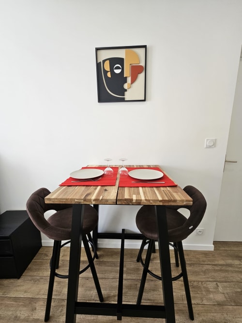 Espace de restauration Studio Mirabeau aux Lodges de Barbieux avec table en bois, chaises marron et œuvres d'art contemporain