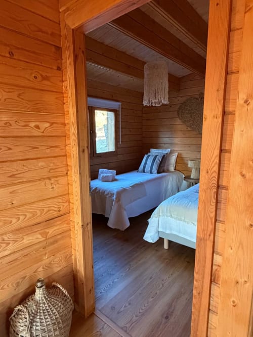 Quarto em madeira da villa Casa do Montado em Corvatos Casas do Monte, Almodôvar com duas camas e vista pela janela