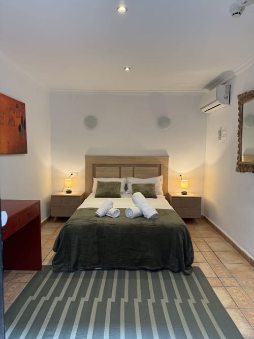Espacioso dormitorio doble en Hotelito Oliva Pensión en Oliva con cama de madera, aire acondicionado y comodidades modernas cerca del