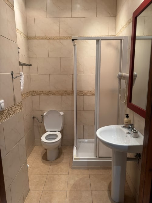 Baño moderno en Hotelito Oliva Pensión con cabina de ducha, lavabo de pedestal e inodoro en Oliva, España
