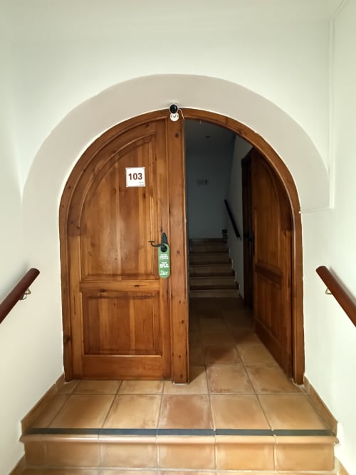 Puerta arqueada de madera numerada 103 en Hotelito Oliva Pensión en Oliva, España