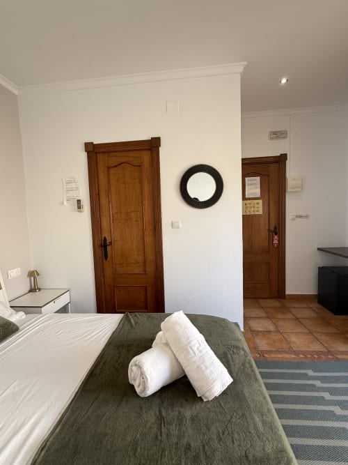 Habitación doble en Hotelito Oliva Pensión en Oliva con camas gemelas, puertas de madera y vistas a la ciudad